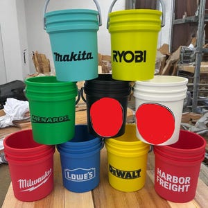 May include: An assortment of colorful plastic buckets with metal handles. The buckets are various colors, including teal, yellow, green, black, white, red, blue, and yellow. Each bucket has a brand name printed on it, such as "Makita", "Ryobi", "Menards", "Milwaukee", "Lowes", "Dewalt", and "Harbor Freight".