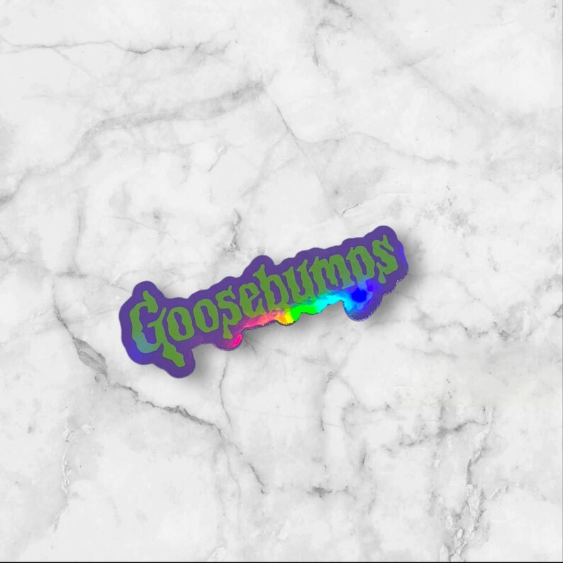 May include: A die-cut sticker featuring the word Goosebumps in a stylized, gothic-inspired font. The lettering displays a vibrant, multi-colored gradient transition from green to yellow, orange, and pink, outlined with a dark purple border.