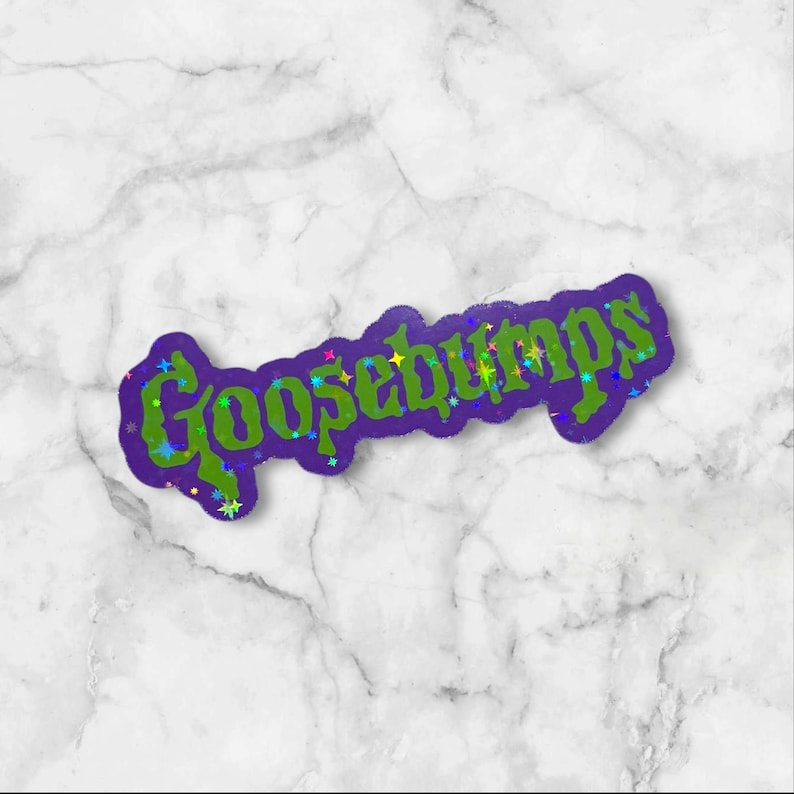 May include: A die-cut sticker featuring the word Goosebumps in a stylized, jagged green font with a dark purple outline. The design is accented with small, multicolored holographic star shapes scattered across the letters, creating a reflective effect.