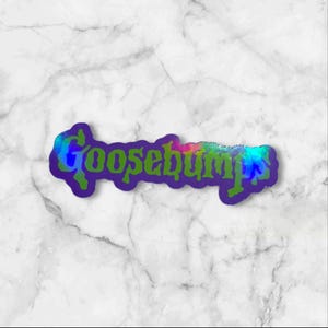 May include: A die-cut sticker featuring the word Goosebumps in a stylized, jagged green font with a dark purple outline. The lettering has a holographic, iridescent finish that reflects various colors across the surface of the text.