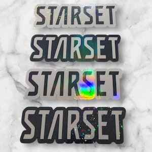 May include: Four silver holographic stickers with the word "STARSET" printed in black letters. The stickers have a glittery, iridescent finish.