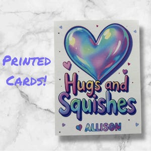 May include: A white card with a rainbow heart and the text "Hugs and Squishes" with the name "ALLISON" below. The card is decorated with small hearts.