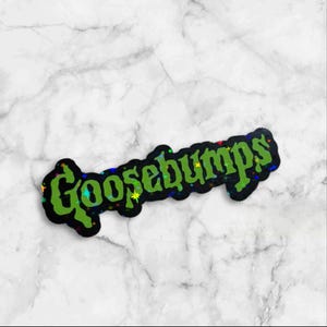 May include: A die-cut sticker featuring the word Goosebumps written in a stylized, jagged green font. The lettering is set against a black background and is accented with small, colorful holographic star shapes scattered throughout the text.