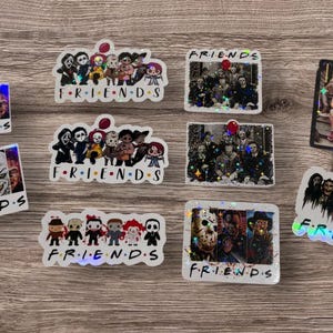 May include: Nine holographic stickers featuring characters from horror movies. Each sticker has the word "FRIENDS" written on it. The stickers are on a wooden surface.