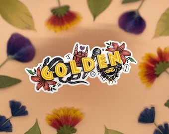 May include: A sticker featuring the word "GOLDEN" in yellow neon lettering, accompanied by a black snake, a microphone, a hand making the rock and roll sign, and flowers.