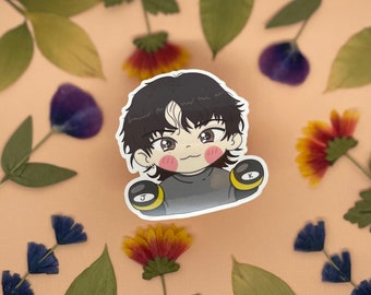 May include: A cartoon sticker of a person with black hair wearing a black shirt and boxing gloves. The gloves are yellow and black with the letters J and K on them. The person has a light pink blush on their cheeks.