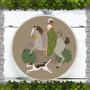 May include: Cross-stitch embroidery in a wooden hoop. The design features a fox riding a gray horse, wearing a green cloak. A dog runs in front of the horse. The background is a light brown color.