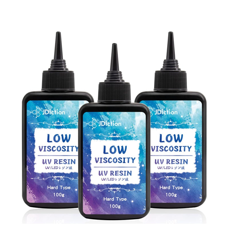 May include: Three bottles of low viscosity UV resin, each labeled "JDiction Low Viscosity UV Resin UV/LEDレジン液 Hard Type 100g". The bottles are clear and have black caps with a dropper tip.