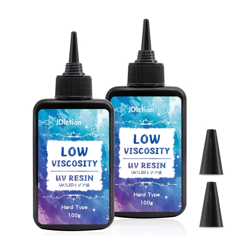 May include: Two bottles of clear low viscosity UV resin, each with a black cap and a label that reads "JDiction Low Viscosity UV Resin UV/LEDレジン液 Hard Type 100g". Two black plastic dispensing tips are also included.