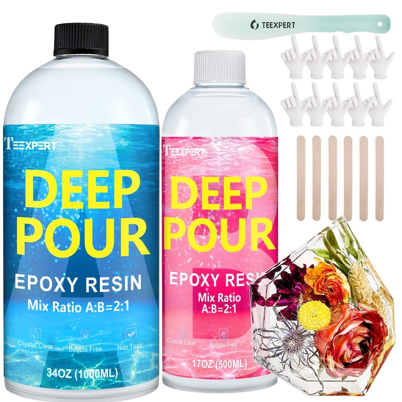 May include: Two clear bottles of epoxy resin, one blue and one pink, labeled "Deep Pour Epoxy Resin". The blue bottle is 34 ounces (1000 ml) and the pink bottle is 17 ounces (500 ml). Both bottles have a mix ratio of A:B=2:1. The bottles are accompanied by wooden stirring sticks, white plastic gloves, and a clear resin project with dried flowers.