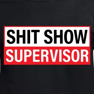 May include: Black t-shirt featuring the text "SHIT SHOW SUPERVISOR" in bold white letters on a red and white rectangular design. The shirt has a crew neck.