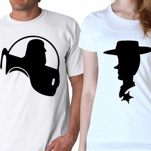 Può includere: Due magliette bianche con silhouette nere di Woody e Buzz Lightyear del franchise di film Toy Story.