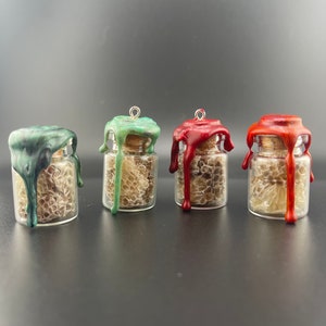 May include: Four small glass jars with cork tops and a wax seal. The jars are filled with honeycomb and sealed with green, red, and orange wax.