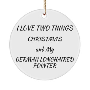 May include: A white ceramic Christmas ornament with a gold string for hanging. The ornament has black text that reads "I LOVE TWO THINGS CHRISTMAS and My GERMAN LONGHAIRED POINTER."