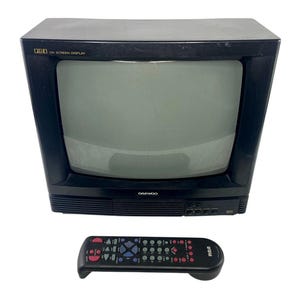 May include: A black Daewoo cathode ray tube television with a gray screen and OSD On Screen Display text in the top left corner. Below the television is a black RCA remote control featuring various colored buttons for device operation.