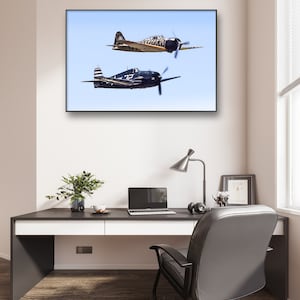 May include: A framed photograph of two vintage fighter planes in flight against a blue sky. The planes are flying in formation, with the larger plane in the foreground and the smaller plane in the background.