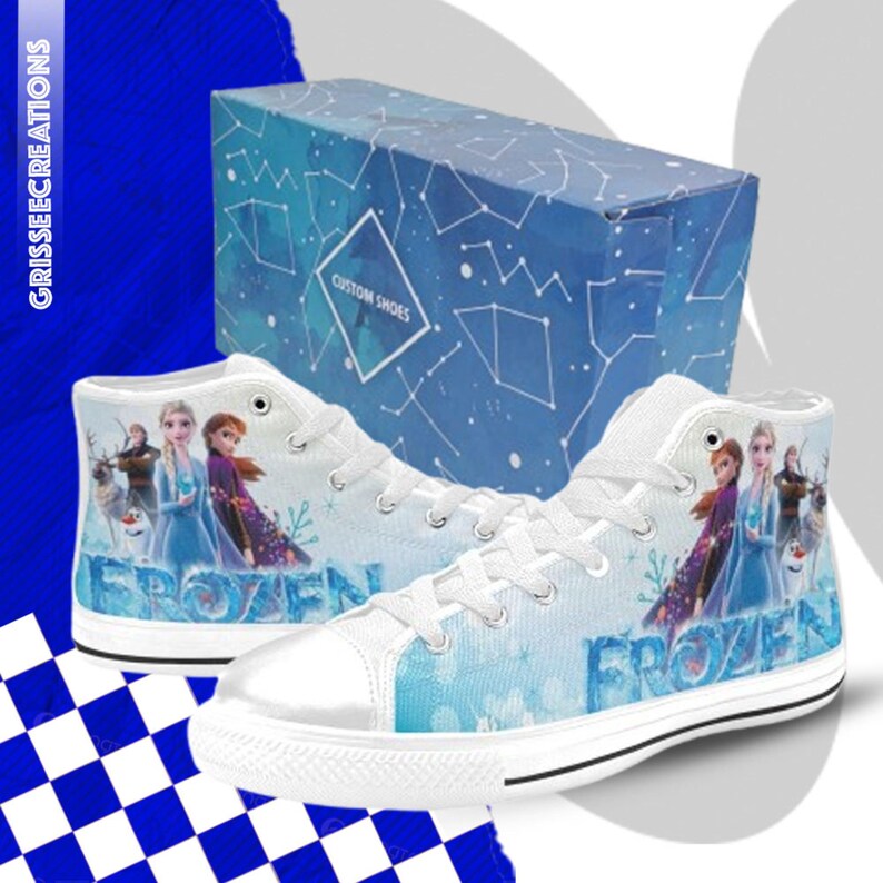 Puede incluir: Zapatillas blancas de lona de ca&ntilde;a alta con un dise&ntilde;o azul y blanco con los personajes de la pel&iacute;cula Frozen. Las zapatillas tienen la palabra "Frozen" impresa.