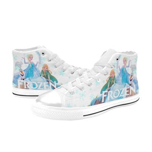 May include: White high-top canvas shoes with a Frozen theme. The shoes feature a snowflake pattern and an image of Elsa, Anna, and Olaf from the movie Frozen. The word "Frozen" is printed on the side of the shoes.