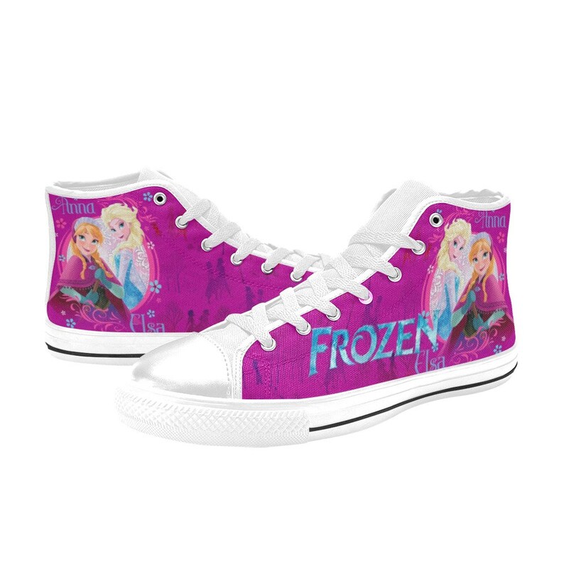 May include: White high-top canvas shoes with a pink background featuring a graphic of Elsa and Anna from the movie Frozen. The text "FROZEN" is printed in blue on the shoes.
