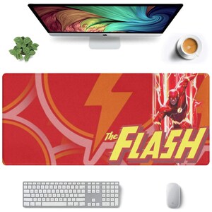 May include: Red and orange mousepad with a graphic of The Flash running with a lightning bolt. The text "The Flash" is in yellow letters.