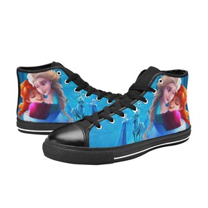 Puede incluir: Zapatillas de lona de ca&ntilde;a alta con un dise&ntilde;o azul y blanco que representa una escena de la pel&iacute;cula animada Frozen. El dise&ntilde;o incluye los personajes de Elsa y Anna, junto con un fondo nevado.