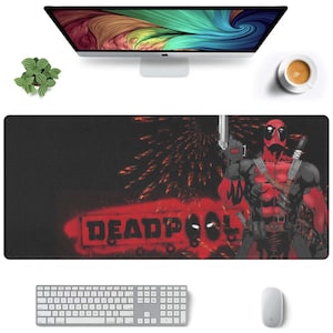 May include: A black and red mousepad with a graphic of Deadpool, a superhero in a red and black suit, holding a gun. The text "DEADPOOL" is written in red on the mousepad.