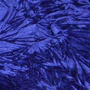 May include: Close-up of a royal blue crushed velvet fabric. The fabric has a soft, textured surface and a luxurious feel.