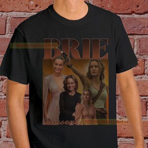May include: Black t-shirt with a collage of images of Brie Larson. The text "BRIE LARSON" is printed in large, bold letters across the top of the image.