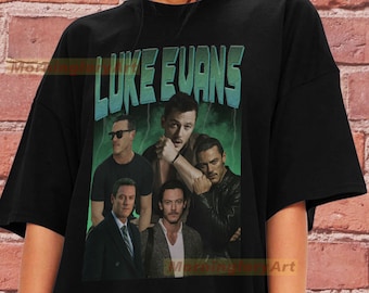 May include: Black t-shirt featuring a vintage-style graphic of Luke Evans. The graphic includes multiple images of Luke Evans in various poses and outfits. The text "LUKE EVANS" is printed in a bold, colourful font.