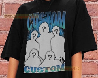 Può includere: T-shirt nera con un design grafico. Il design presenta la parola "CUSTOM" in blu e verde, insieme a cinque sagome con punti interrogativi. Il design ha uno stile retrò e aerografato.