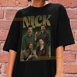 May include: Black t-shirt featuring a vintage-style graphic of the cast from the TV show "The Good Place", with the text "Nick Offerman" and "Nick" in large yellow letters.