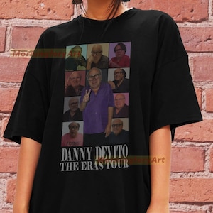 May include: Black t-shirt with a collage of images of Danny DeVito in different roles. The text "Danny DeVito The Eras Tour" is printed below the images.