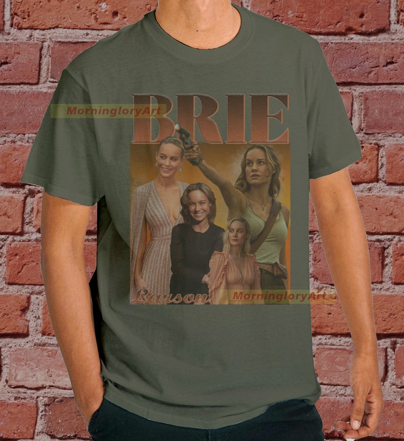 May include: A green t-shirt with a vintage-style graphic of Brie Larson. The graphic features multiple images of Brie Larson in different poses, with the word "BRIE" in large, bold letters above the images.