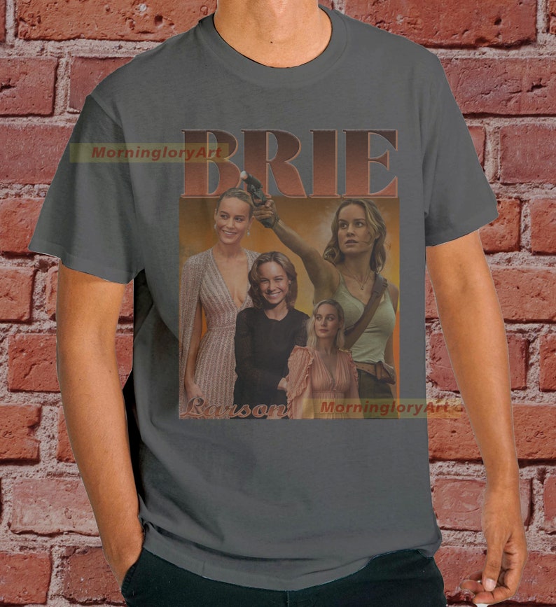 May include: A gray t-shirt with a collage of images of Brie Larson in different roles. The text "BRIE LARSON" is printed in a retro style font.