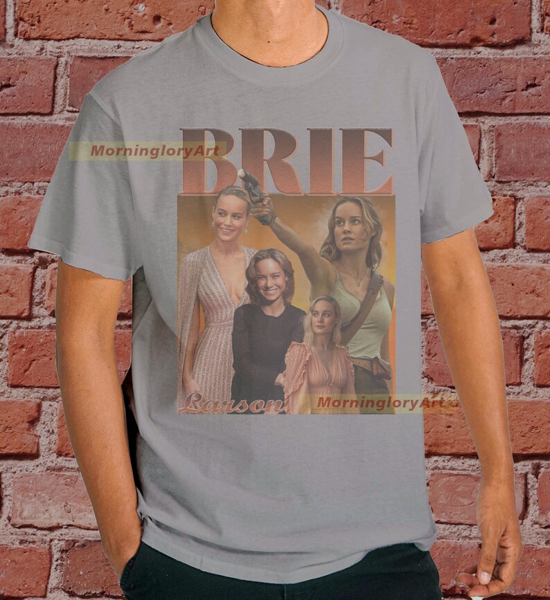 May include: A gray t-shirt with a collage of images of Brie Larson. The text "BRIE LARSON" is printed on the shirt in a retro style.