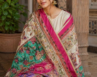 May include: A richly embroidered shawl with a vibrant colour palette. The design incorporates pink, green, and cream hues, with a detailed paisley pattern. The shawl is finished with a bright pink border along the edges.