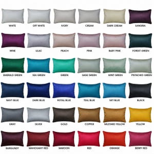 May include: A grid of thirty-six rectangular throw pillows displayed in various solid colours including white, off-white, ivory, cream, sangria, wine, lilac, peach, pink, baby pink, forest green, emerald green, sea green, green, sage, mint, and pistachio.