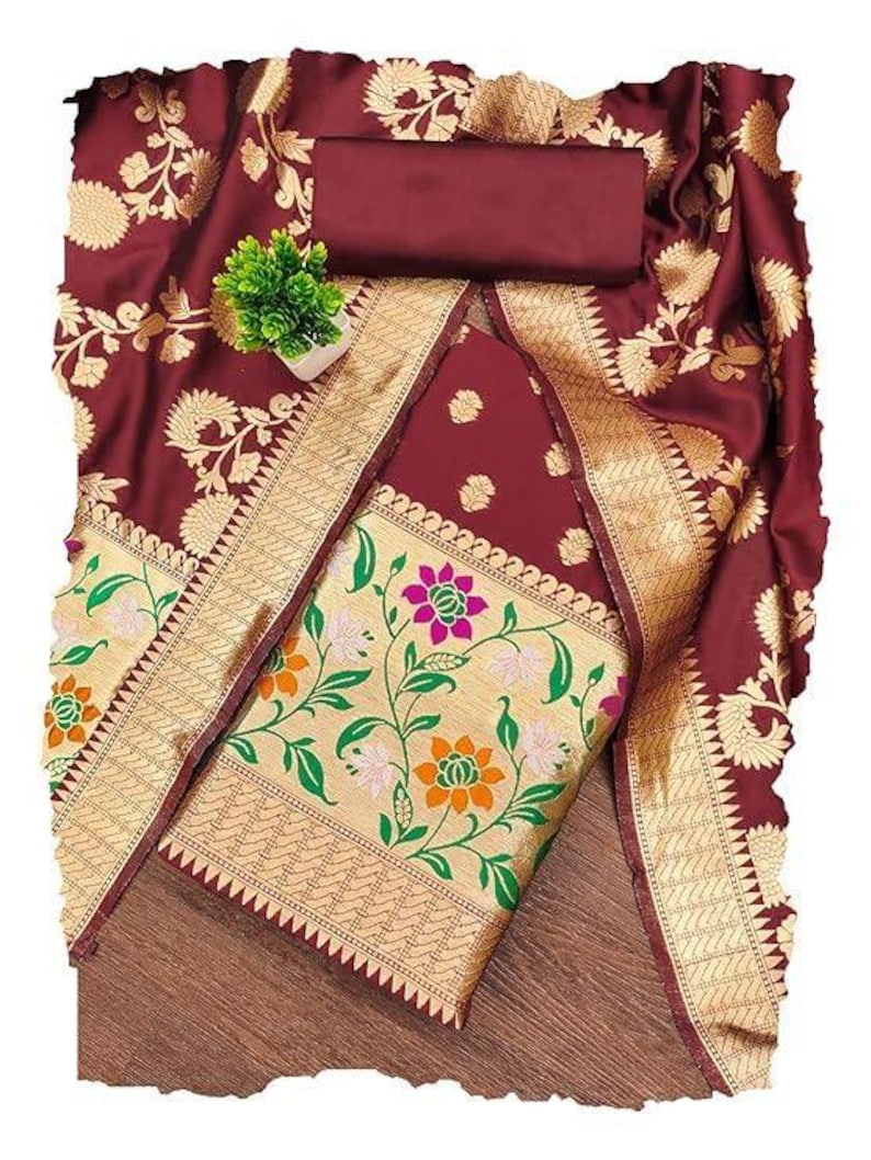 May include: A deep maroon fabric set featuring intricate gold floral patterns and a wide border. The textile displays a central panel with colourful pink, orange, and white flower motifs on a gold background, complemented by a solid maroon piece.