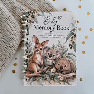 May include: A spiral-bound baby memory book with a white cover featuring watercolour illustrations of a kangaroo, a koala, and a wombat surrounded by eucalyptus leaves. The text reads Baby Memory Book, A Keepsake of Love, Milestones & Precious Moments.