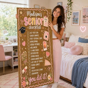 May include: A large rectangular brown sign titled Madison's Senior checklist with a pink and white floral border. The list includes milestones like Last First Day, Homecoming, and Graduation, decorated with icons of a cap, camera, and scroll.
