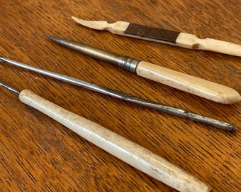Antichi strumenti da cucito britannici: strumenti per chiacchierino in osso, stiletto in acciaio e uncinetto.
