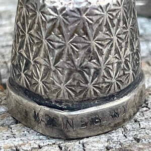 May include: Silver thimble with a starburst pattern and the words "Made in England" engraved on the bottom.