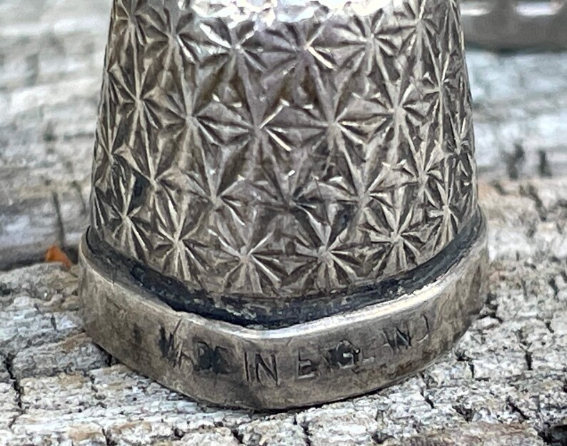 May include: Silver thimble with a starburst pattern and the words "Made in England" engraved on the bottom.