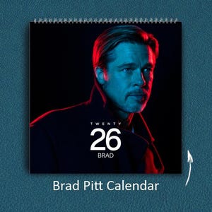 Könnte beinhalten: Ein Spiral-Kalender mit einem Porträt von Brad Pitt, beleuchtet in Rot und Blau. Der Kalender zeigt die Zahl "26" und den Namen "Brad" in Weiß. Der Text "Brad Pitt Calendar" befindet sich am unteren Rand des Bildes.
