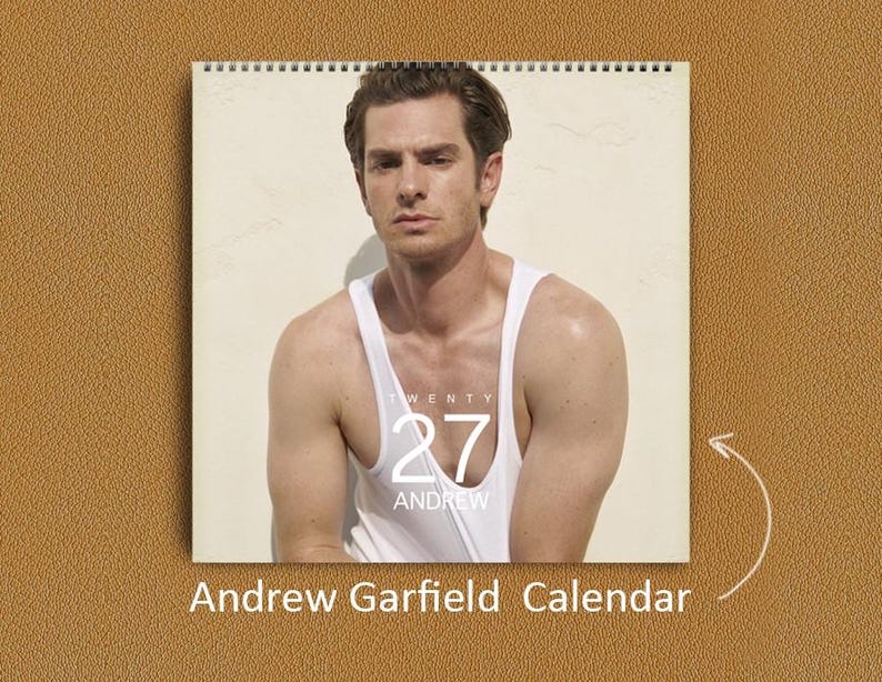 May include: A wall calendar featuring a portrait of Andrew Garfield wearing a white tank top. The calendar cover displays the text TWENTY 27 ANDREW in white lettering. The calendar is spiral bound at the top and includes the text Andrew Garfield Calendar.