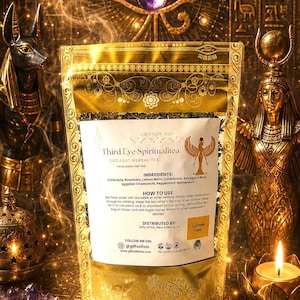 以下が含まれることがあります： Third Eye Spiritualiteaのオーガニックハーブティーが入った金色のスタンドパウチ。ラベルには、カレンデュラ、ローズマリー、レモンバーム、カルダモン、アストラガルス根、エジプト産カモミール、ペパーミント、マザーワートなどの原材料と、淹れ方の説明が記載されています。