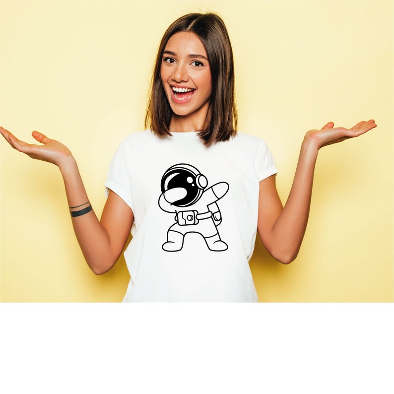 K&ouml;nnte beinhalten: Wei&szlig;es T-Shirt mit einer schwarz-wei&szlig;en Illustration eines Astronauten, der den Dab macht.