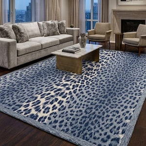 May include: A large blue and white patterned area rug with a leopard print design. The rug is rectangular and covers a dark wood floor. The room also features a gray sofa, chairs, and a coffee table.