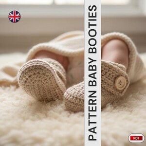 Peut inclure: Gros plan sur des chaussons de b&eacute;b&eacute; en crochet beige avec une fermeture &agrave; bouton. Le texte "PATTERN BABY BOOTIES" est affich&eacute; verticalement. Les chaussons sont sur une surface douce et blanche.