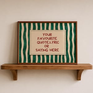 Op de afbeelding: Een rechthoekige ingelijste print met een crèmekleurig centraal paneel met een geschulpte rand en de rode tekst: YOUR FAVOURITE QUOTE, LYRIC OR SAYING HERE. De achtergrond bestaat uit verticale, handgetekende donkergroene golvende strepen.